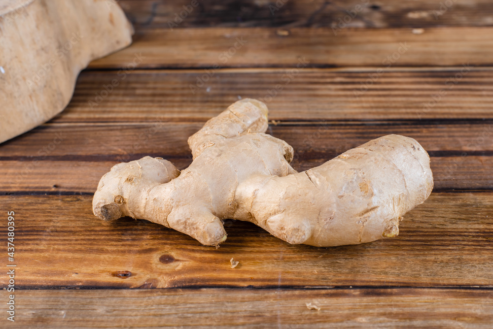 fresh ginger root on rustic wooden board blackground