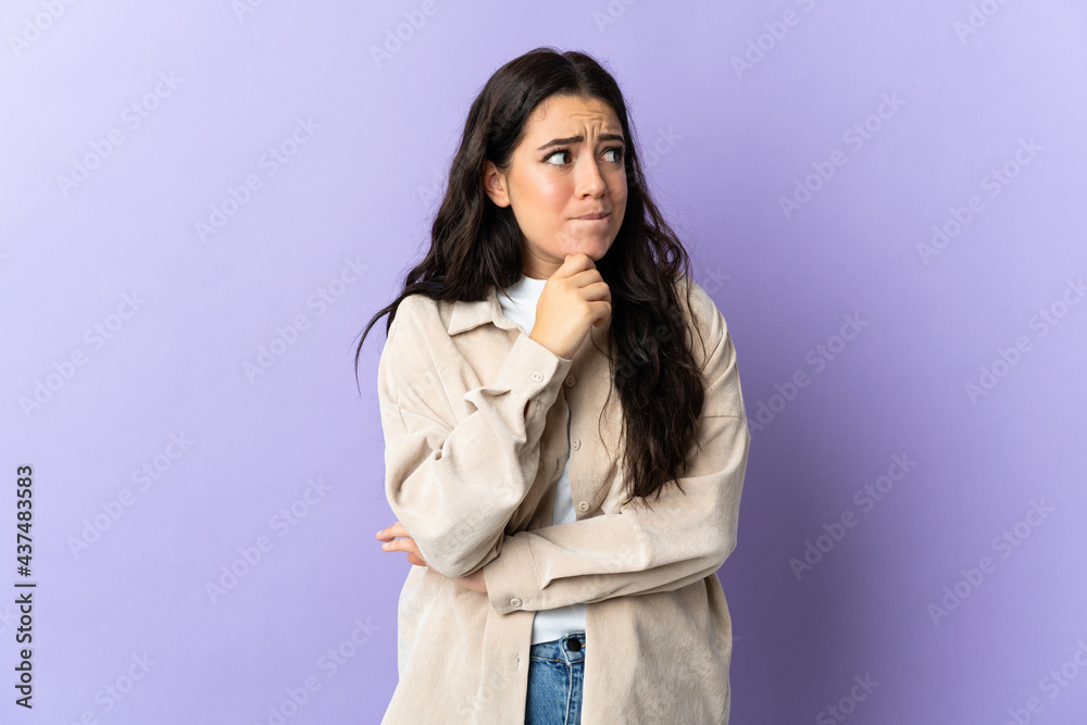Young caucasian woman isolated on purple background having doubts and thinking Young caucasian woman isolated on purple background having doubts and thinking