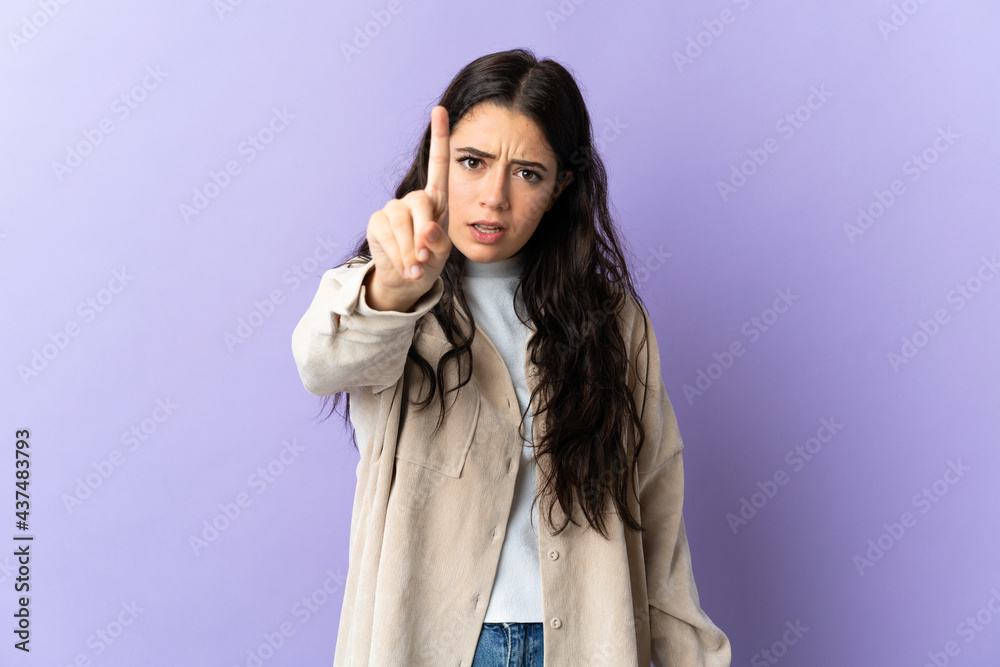 Young caucasian woman isolated on purple background counting one with serious expression Young caucasian woman isolated on purple background counting one with serious expression