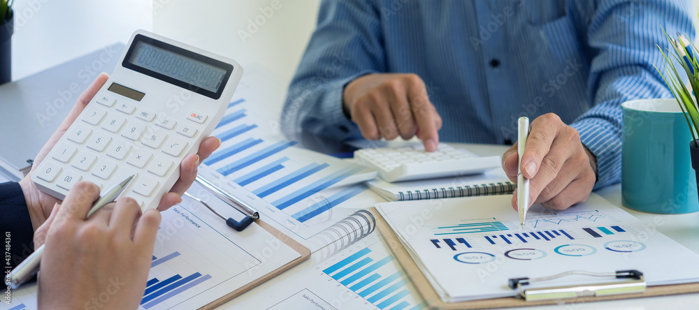 A young businessman working on a new start-up project. Laptop on a wooden table in the company's graphing and calculating office.. A young businessman working on a new start-up project. Laptop on a wooden table in the company's graphing and calculating office..