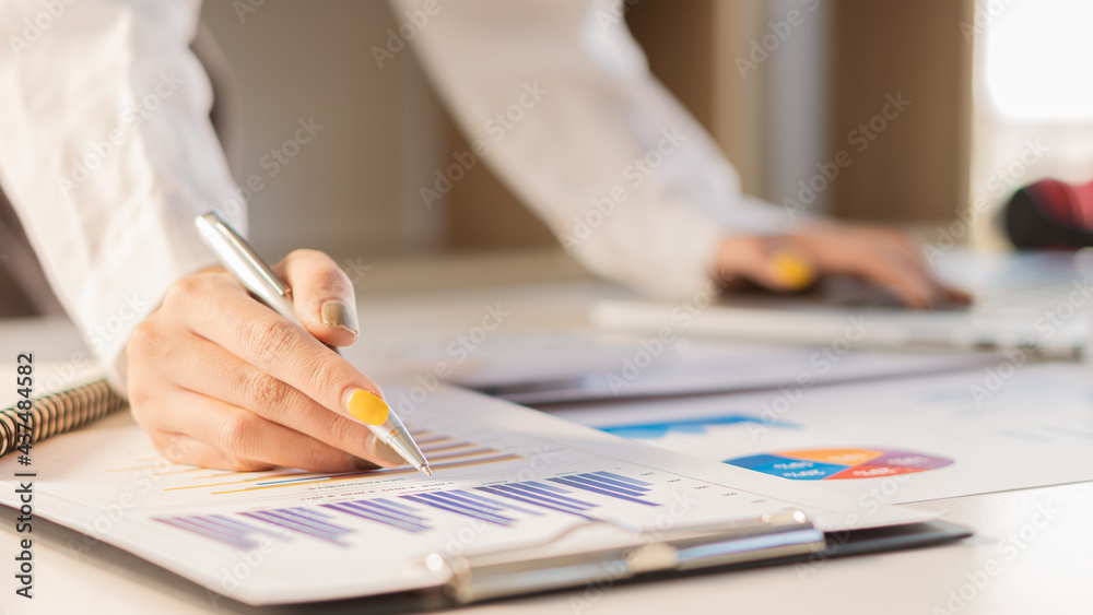 A young businessman working on a new start-up project. Laptop on a wooden table in the company's graphing and calculating office.. A young businessman working on a new start-up project. Laptop on a wooden table in the company's graphing and calculating office..
