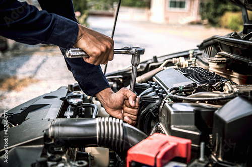 Car care maintenance and servicing, Close-up hand technician auto mechanic using the wrench to repairing car engine problem. Concepts of check and during car periodic inspection service.