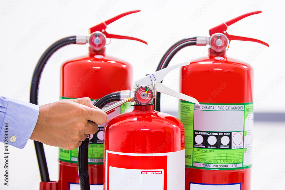 Obraz premium Fire extinguisher, Firefighter use inspection list checking pressure gauge level of fire extinguisher tank in the building of protection and prevent for emergency and safety rescue and fire training.