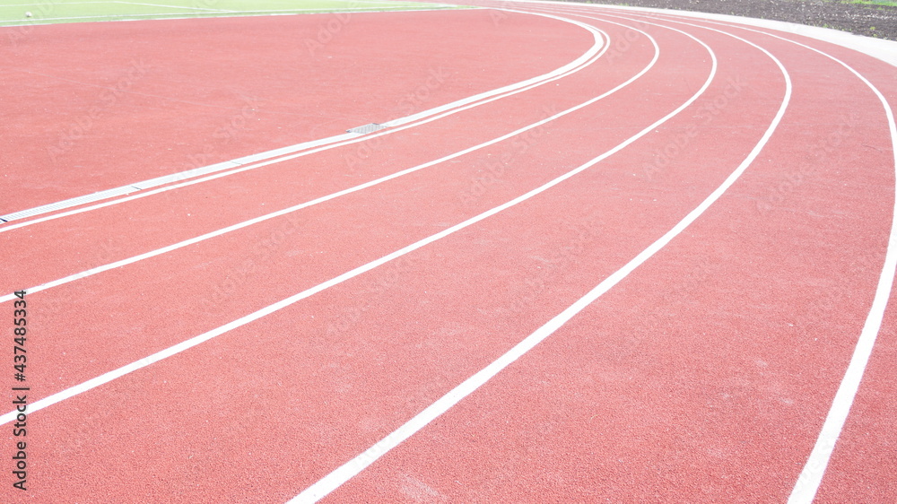 Running track in red with a carbon coating around the stadium with white dividing stripes