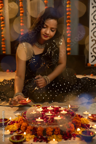 Portrait of an Indian woman holding diyas and lamps on the festive occasion of Diwali. Celebrations at home