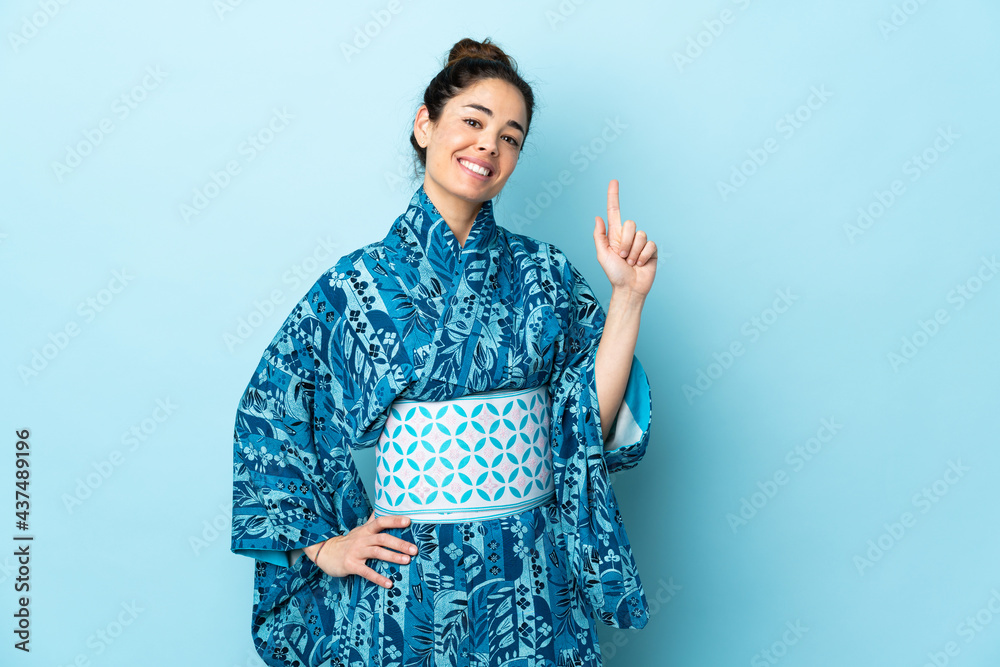 Woman wearing kimono over isolated background showing and lifting a finger in sign of the best Woman wearing kimono over isolated background showing and lifting a finger in sign of the best
