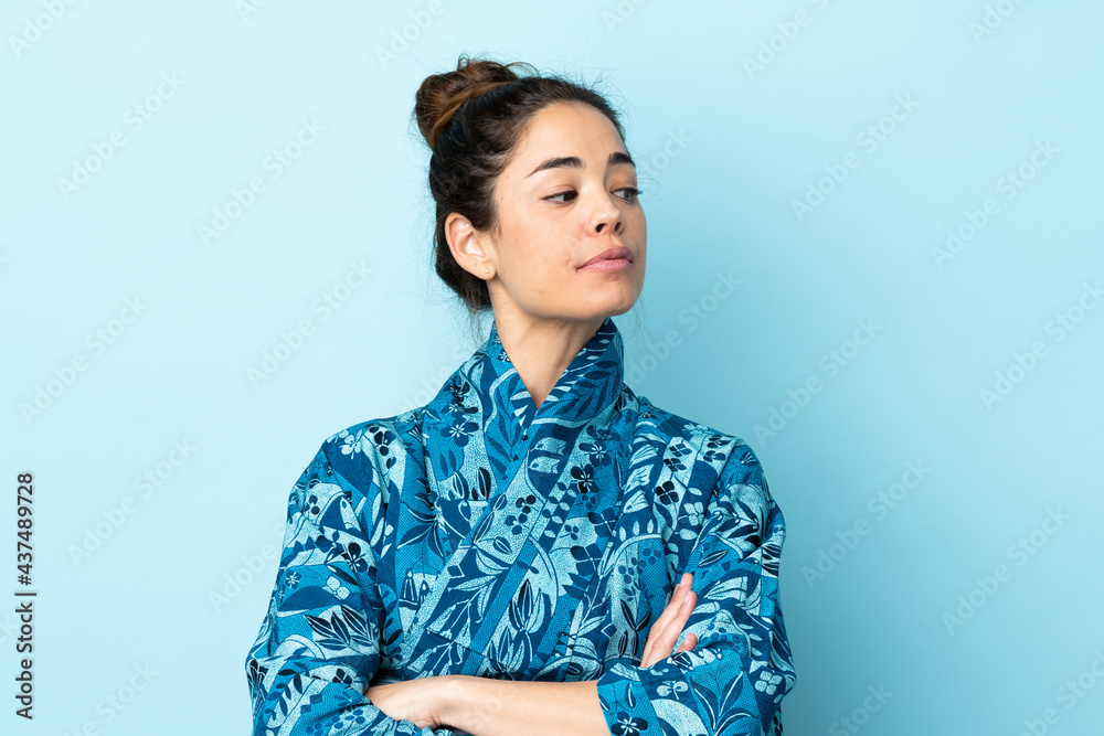Woman wearing kimono over isolated background keeping the arms crossed Woman wearing kimono over isolated background keeping the arms crossed
