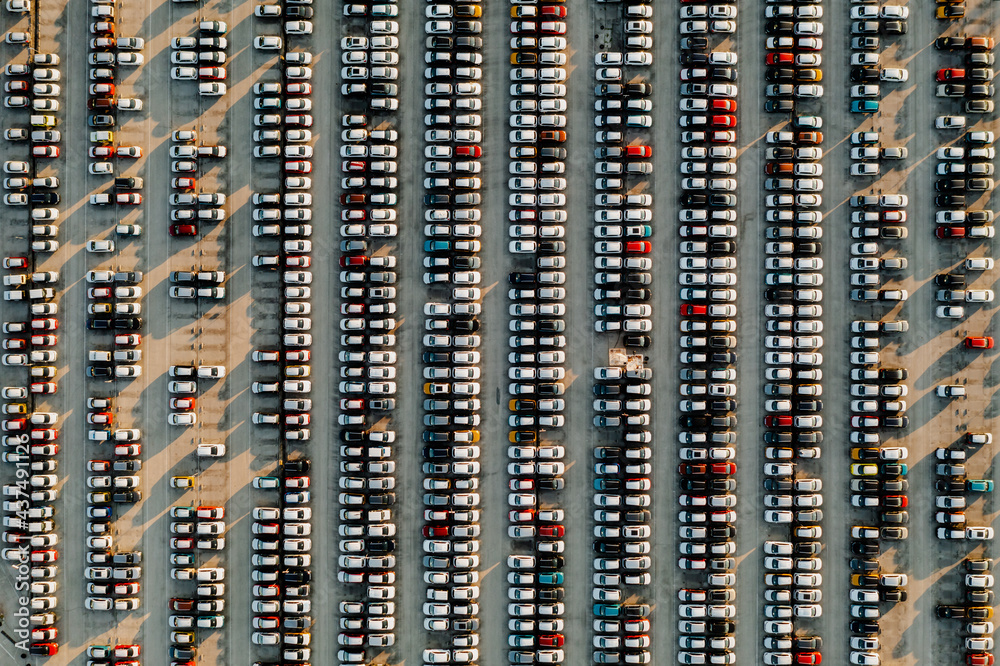 Aerial view new cars lined up in the parking station for import and export business logistic to dealership for sale, Automobile and automotive car parking lot for commercial business industry.