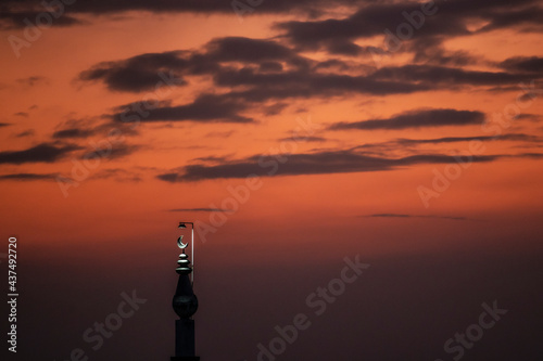 Sunset over a Mosque Minaret which is top lit. 