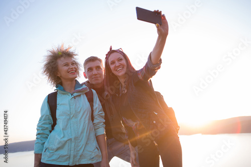 Group of friends resting on mountain while hiking. Hikers relaxing and taking selfie. Friends Taking Selfie at Top of Mountain Hiking in the mountains