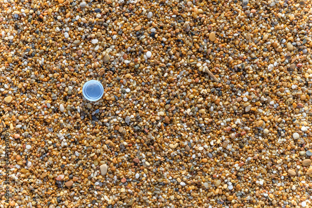 Plastic water bottle cap on the sand at the beach Plastic water bottle cap on the sand at the beach