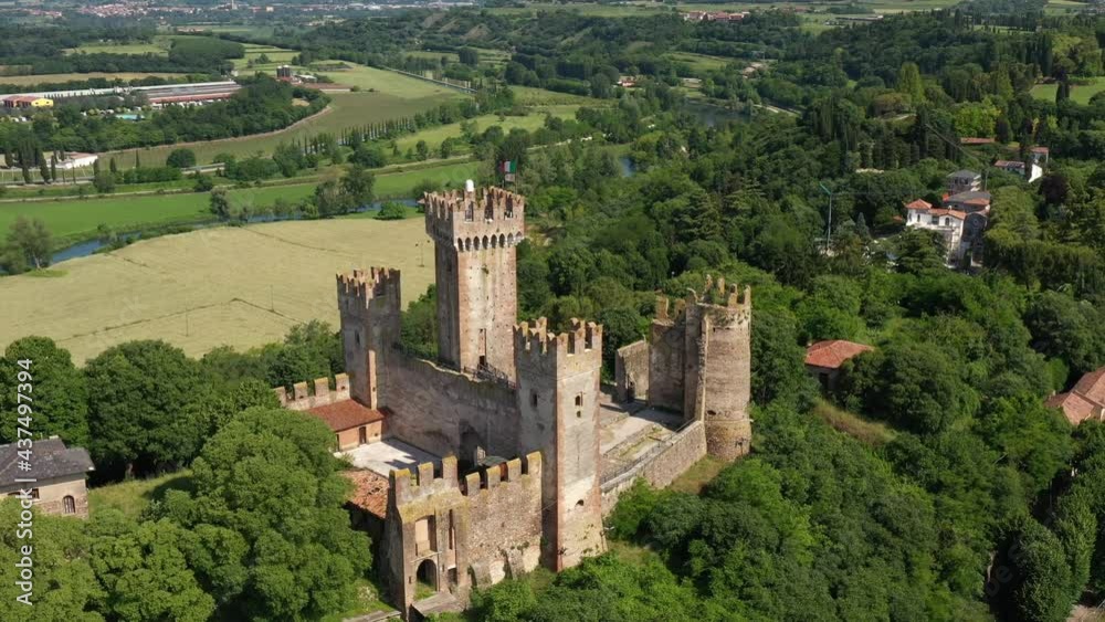Aerial view of the Italian historic castle Castello Scaligero on a hill, view of the Ponte Visconteo bridge and the Mincio river. Flag of Italy at Scaligero Castle, Verona, Italy. Aerial view of the Italian historic castle Castello Scaligero on a hill, view of the Ponte Visconteo bridge and the Mincio river. Flag of Italy at Scaligero Castle, Verona, Italy.
