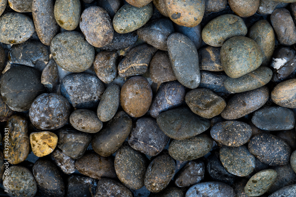 Small stone texture for background. Group of brown, grey and black pebbles, flat lay texture in daylight Small stone texture for background. Group of brown, grey and black pebbles, flat lay texture in daylight