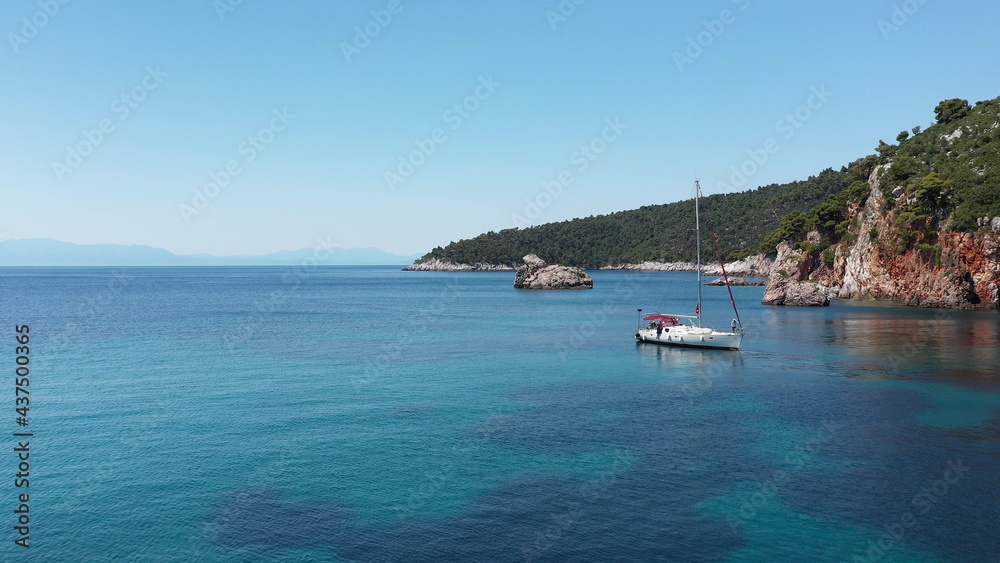 Drone aerial view of tourists enjoying a paradise luxury Yacht trip around Skopelos island, Greece, Aegean Sea, Europe.