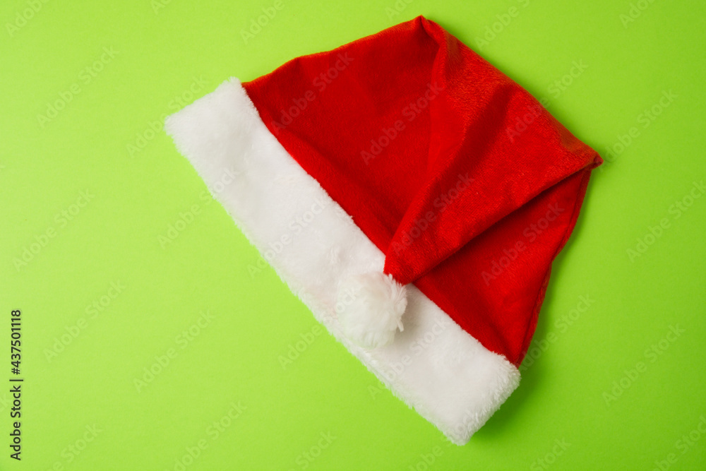 Santa claus hat on bright green background close up copy space Santa claus hat on bright green background close up copy space