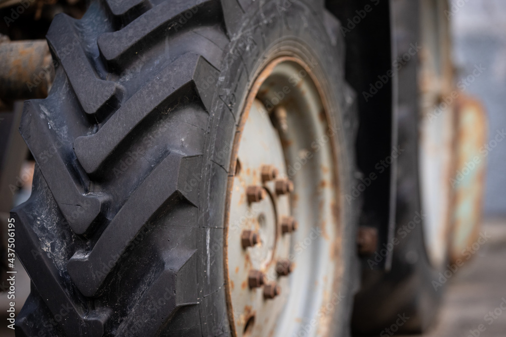 Close-up of the front wheel of a tractor Belarus. Strong tire tread on the wheel. Rural life Close-up of the front wheel of a tractor Belarus. Strong tire tread on the wheel. Rural life