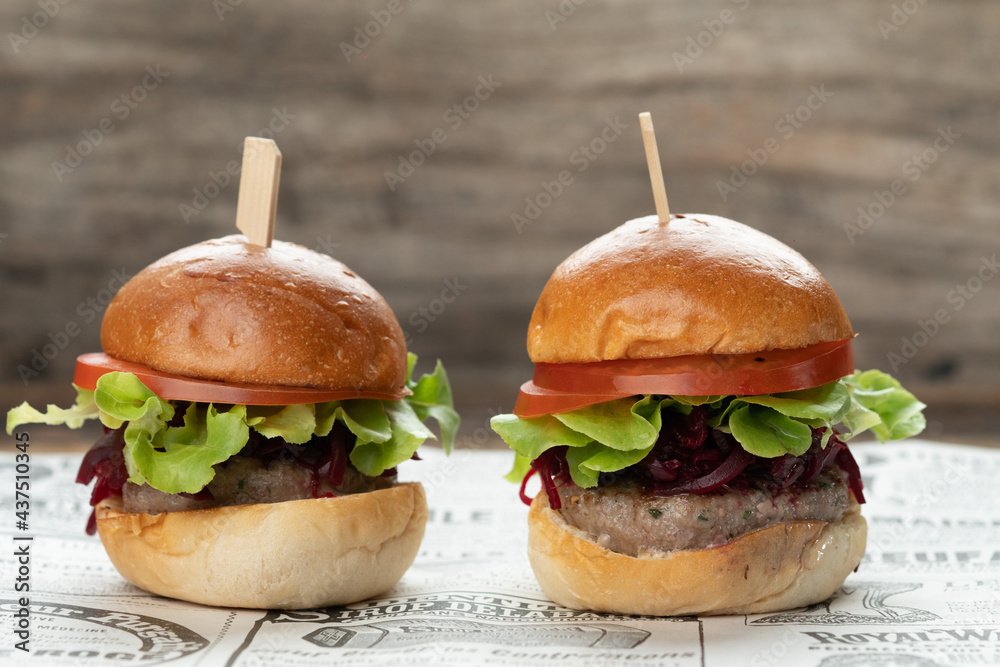 Two mini beef burgers with beetroot relish. Beef patties on two brioche buns with lettuce and beetroot - obrazy, fototapety, plakaty 