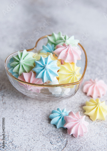 Small colorful meringues in the heart shaped bowl