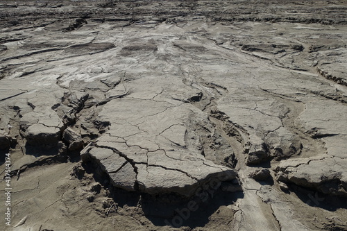 Water-washed land. Cracked crumbling clay and sandy soil after the snow melts in the spring or flood. concept of soil erosion climate change and sudden changes in air temperature and natural disasters