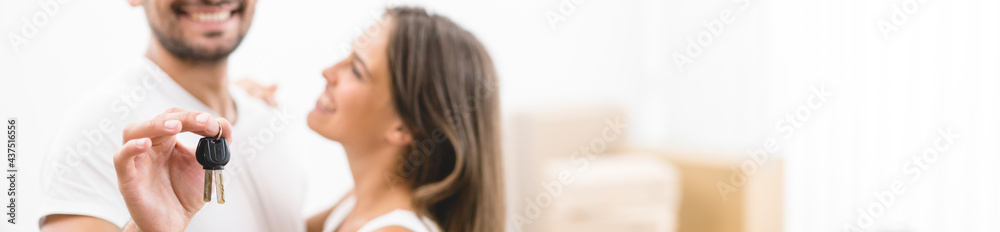 The couple hold keys on the background of the carton boxes The couple hold keys on the background of the carton boxes