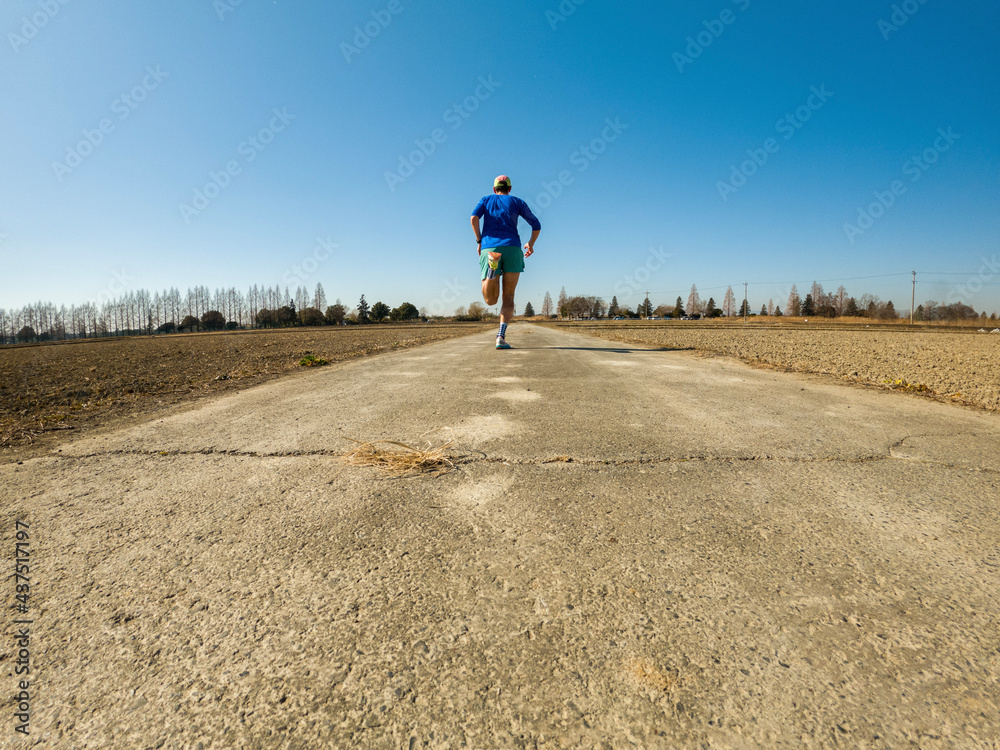 Obraz premium Male runner exercising on countryside road