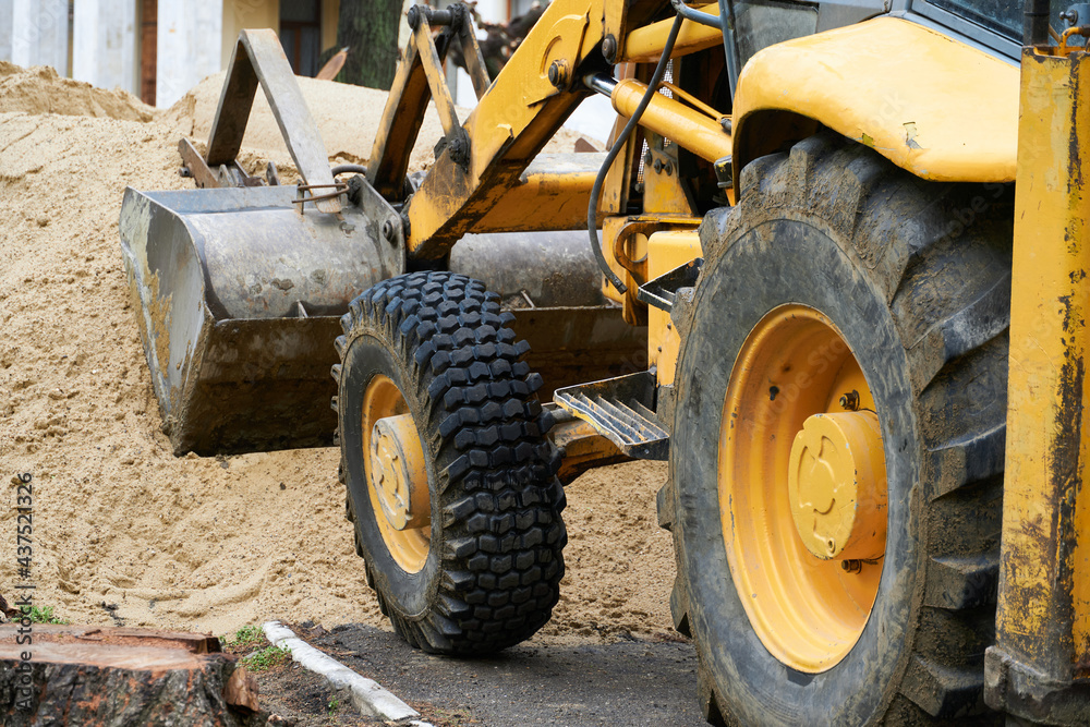 tractor or bulldozer works with a pile of sand for construction tractor or bulldozer works with a pile of sand for construction