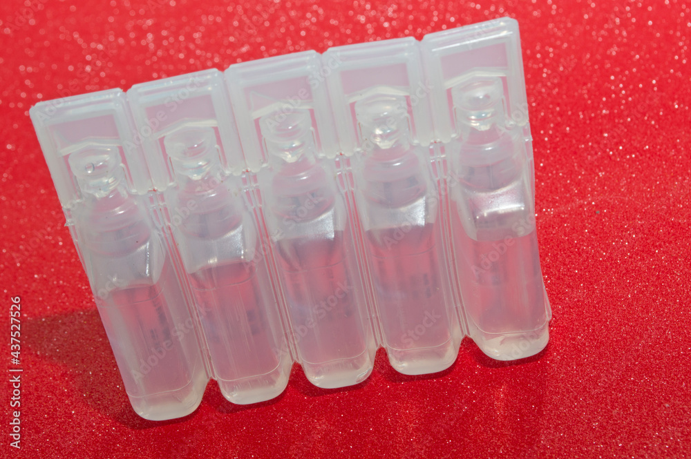 Plastic packaging with anti-inflammatory injection on a red background. Plastic packaging with anti-inflammatory injection on a red background.