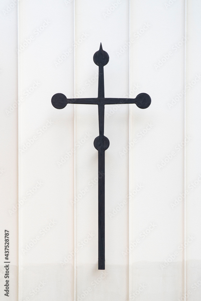 Catholic metal cross on a white wall
