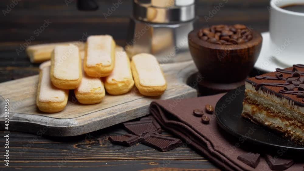 Portion of Traditional Italian Tiramisu dessert, cup of espresso, mocha and coffee beans