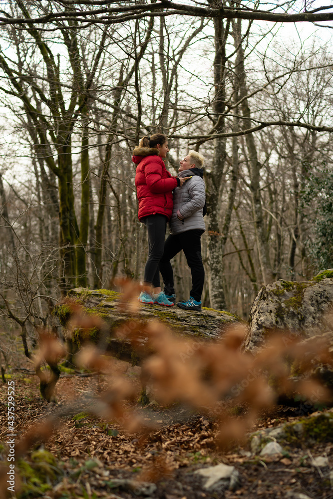 women mountaineers help each other walking along a trail women mountaineers help each other walking along a trail