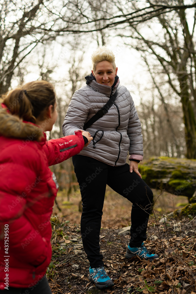 women mountaineers help each other walking along a trail women mountaineers help each other walking along a trail