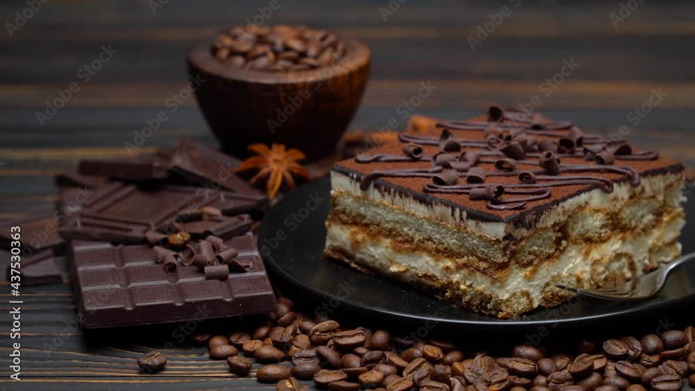 Portion of Traditional Italian Tiramisu dessert and pieces of chocolate bar Portion of Traditional Italian Tiramisu dessert and pieces of chocolate bar