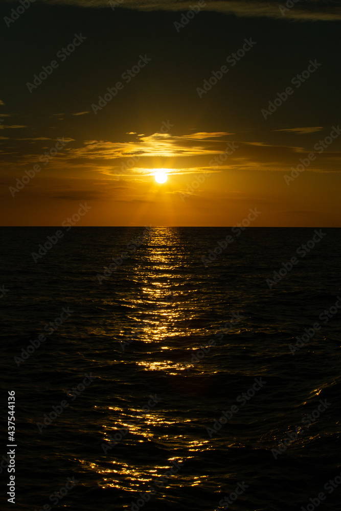 sunset in the middle of the sea with silhouette of the ocean