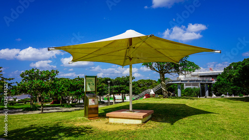 沖縄の青い空と青い海、海洋博公園の総合案内所（ハイハイプラザ）付近のパラソル