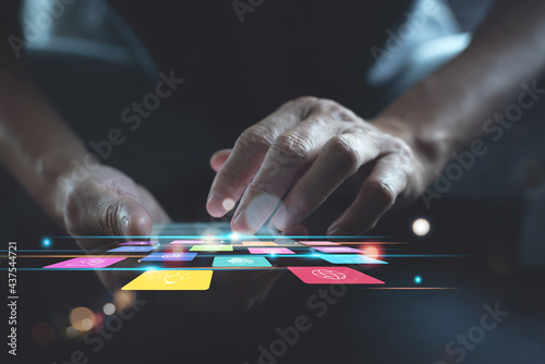 Man using smartphone with colourful mobile apps on virtual screen, digital software technology development concept photo