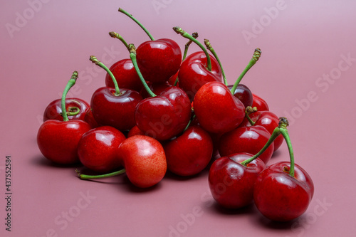 Pile of fresh cherries on pink background