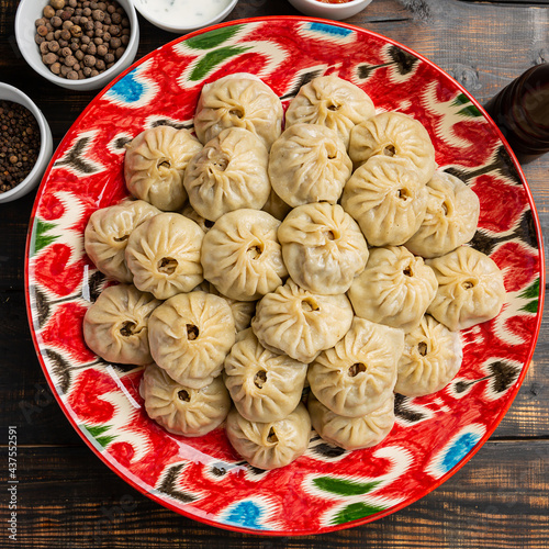 Stuffed dumplings, manti of dough and minced on wooden background