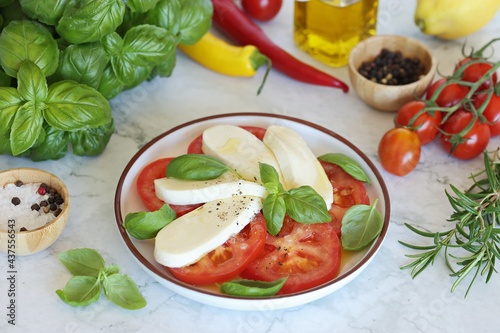 Traditional Italian Caprese salad with tomatoes, mozzarella cheese and basil leaves. Selective focus
