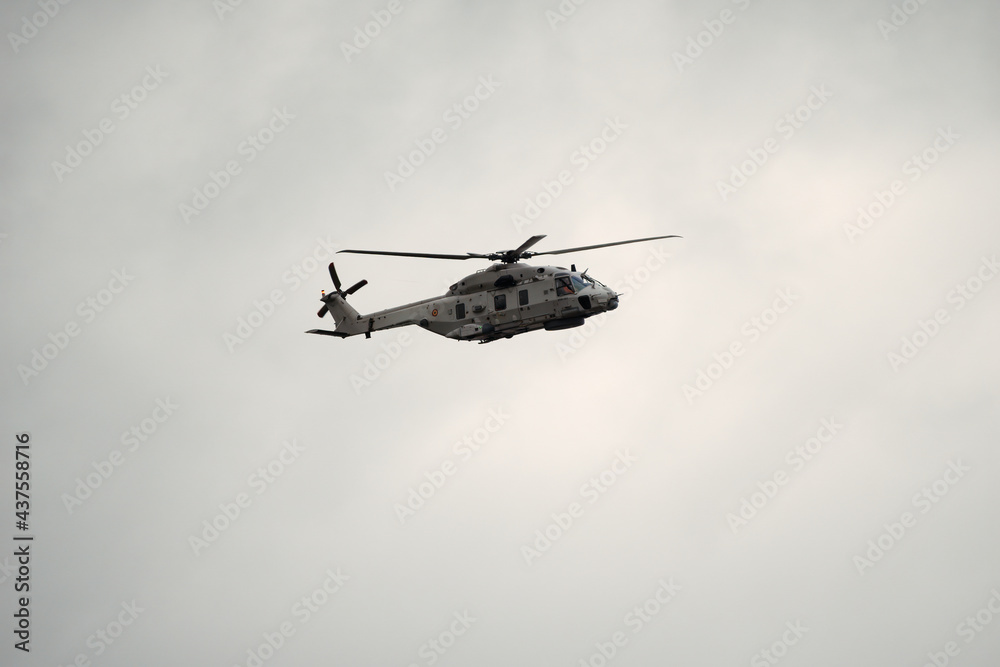 Fototapeta premium Sea military helicopter (airforce) in flight at Koksijde on a rainy and cloudy day ready for combat