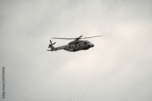 Fototapeta Naklejka Na Ścianę i Meble -  Sea military helicopter (airforce) in flight at Koksijde on a rainy and cloudy day ready for combat