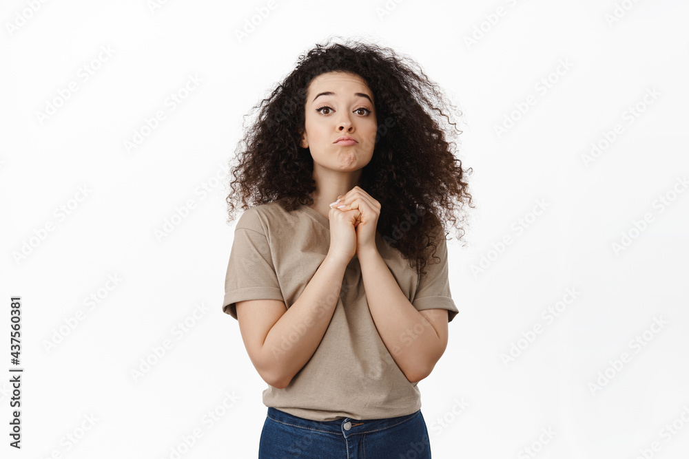 Cute coy brunette girl pucker lips and looking needy, wanting and begging for something, asking to buy thing, pretty please face, standing clingy against white background Cute coy brunette girl pucker lips and looking needy, wanting and begging for something, asking to buy thing, pretty please face, standing clingy against white background