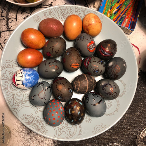 Originally painted, in the form of emotions and faces, Easter eggs on a decorative plate photo