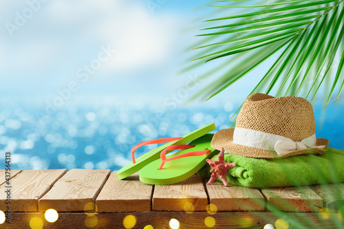 Canvas Print Tropical summer concept with beach accessories on wooden board over sea beach background