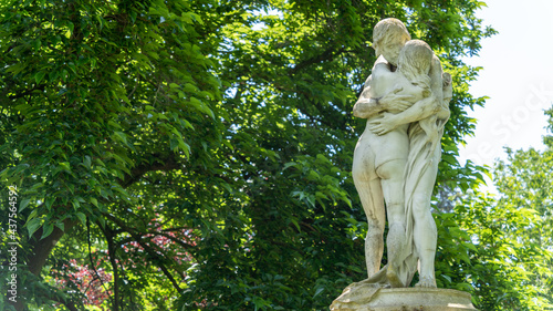 Foto Pretty statues of a hugging couple, surrounded by trees and flowers