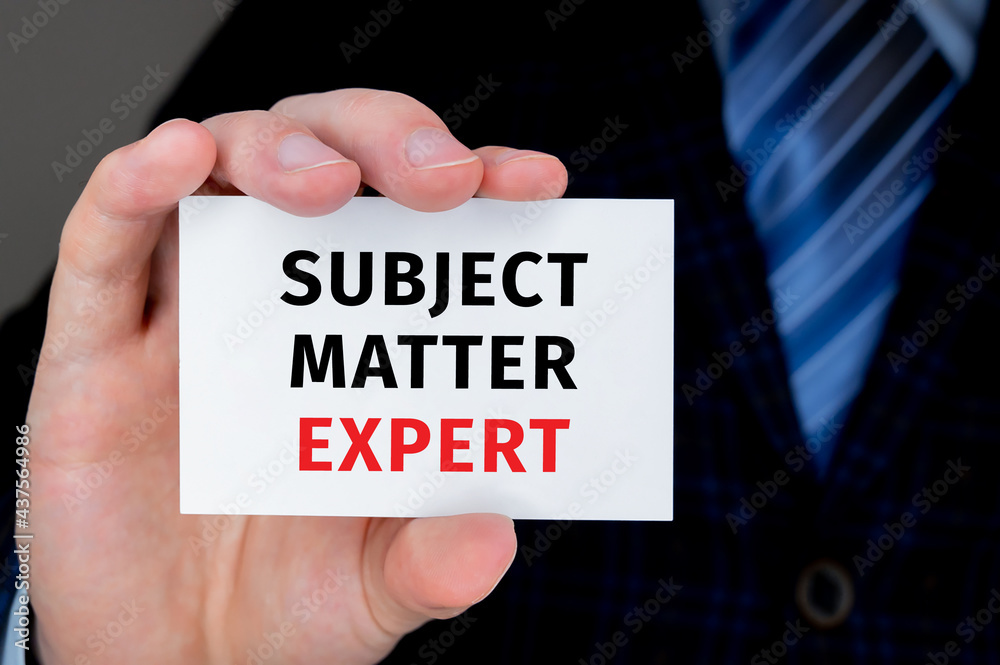 Closeup on businessman holding a card with SUBJECT MATTER EXPERT message, business concept image with soft focus background and vintage tone Closeup on businessman holding a card with SUBJECT MATTER EXPERT message, business concept image with soft focus background and vintage tone