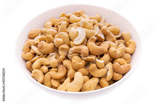 lightly roasted cashew nuts in a white bowl close-up.isolated food products