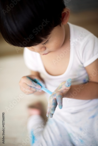 Little asian boy playing crayon on hand: close up