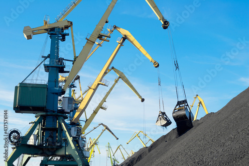 Mountains of coal on the territory of the Murmansk Commercial Sea Port. The unloading of wagons with coal and the loading of this coal into industrial sea ships are going all day and night.