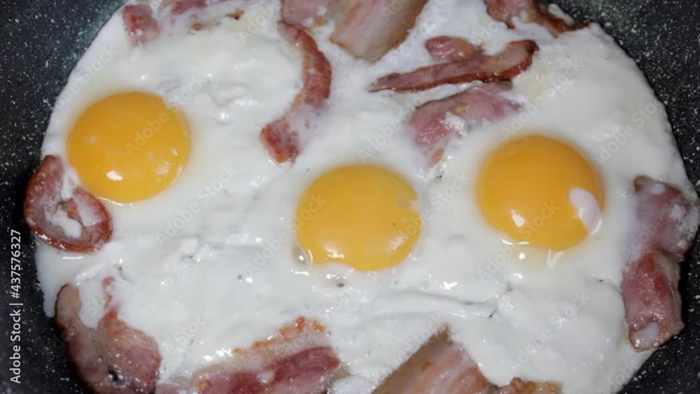 Fried eggs with bacon in a pan, close-up Fried eggs with bacon in a pan, close-up