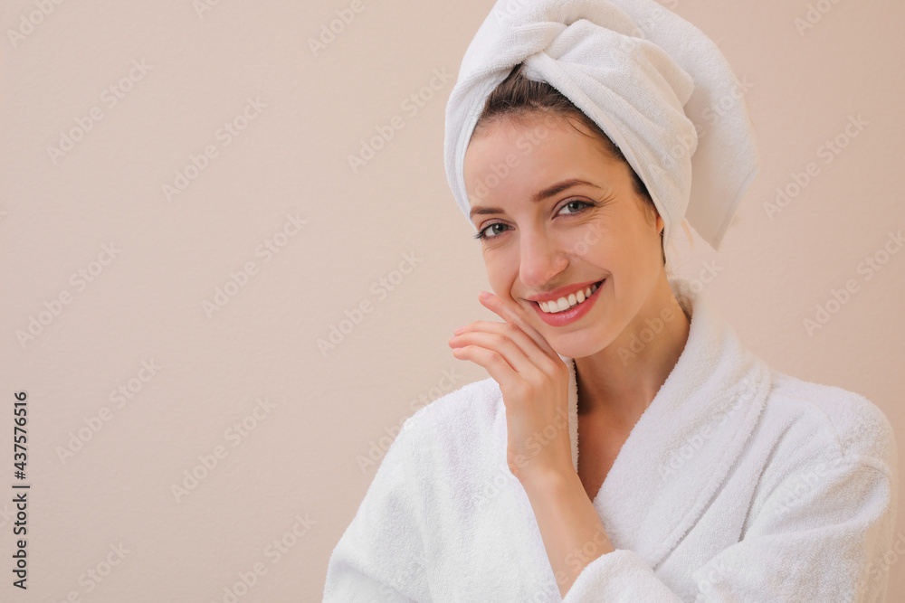 Beautiful young woman with hair wrapped in towel after washing on beige background. Space for text Beautiful young woman with hair wrapped in towel after washing on beige background. Space for text